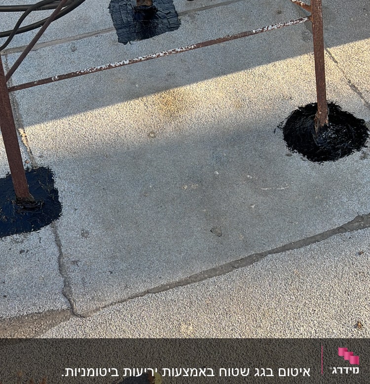 איטום בסיסי מתכת עם חומר שחור על רצפה